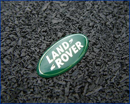 detail of domed badge on recycled binder of car tyres and paper